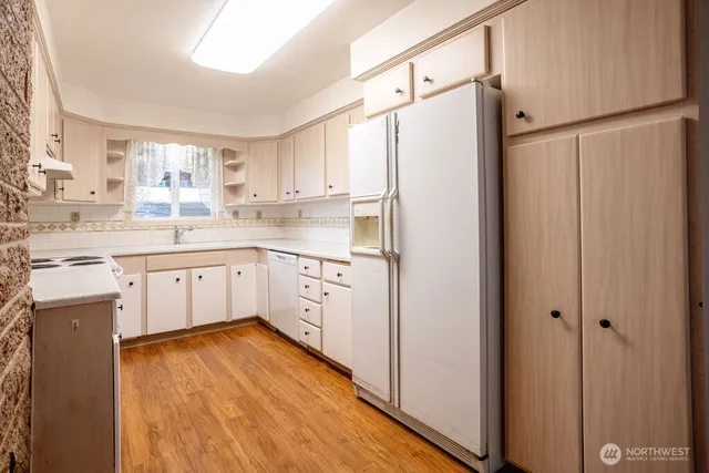 a kitchen with white cabinets and white stainless steel appliances