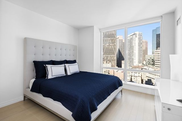a large bed sitting in a bedroom next to a window