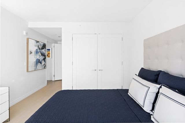 a view of a livingroom with wooden floor and a black white wall