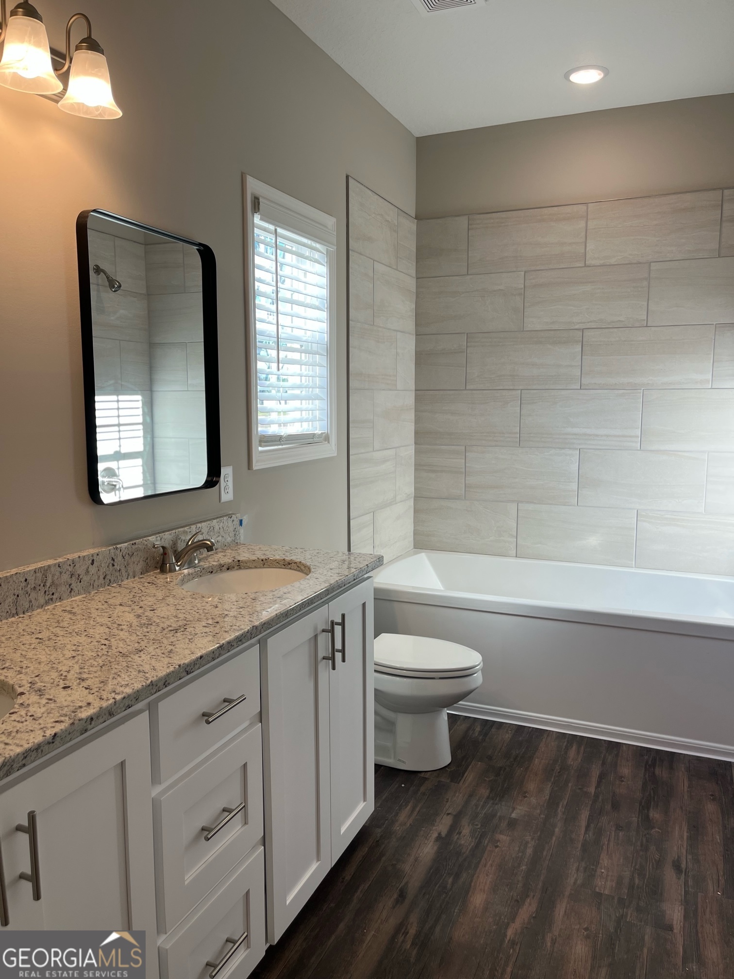 127 Orchard Way Brooklet, GA 30415 - Photo 12 of 15 a bathroom with a granite countertop toilet a sink and a mirror