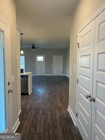 a view of a hallway with wooden floor and staircase