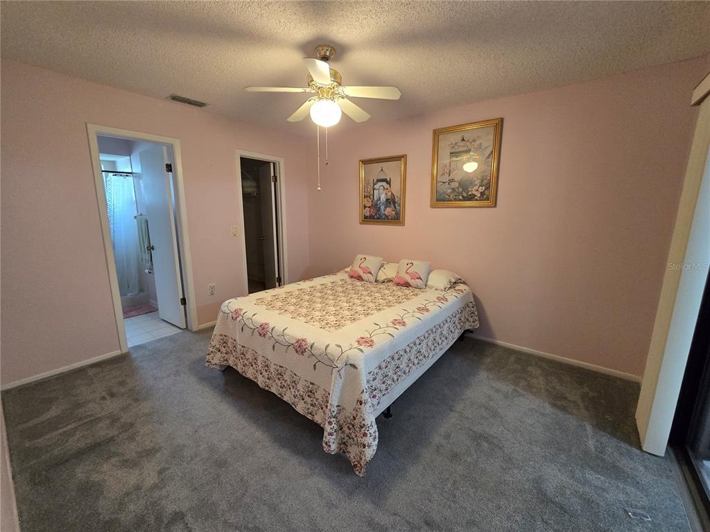 8055 Picketts Court, Unit 8055 Weeki Wachee, FL 34613 - Photo 11 of 22 a bedroom with a bed and a chandelier