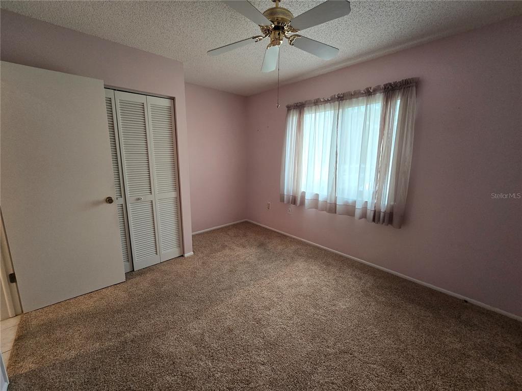 8055 Picketts Court, Unit 8055 Weeki Wachee, FL 34613 - Photo 17 of 22 an empty room with windows and fan