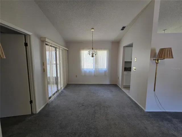 an empty room with windows and refrigerator