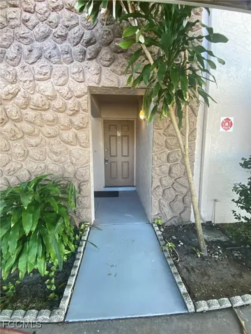a front view of a house with a tree