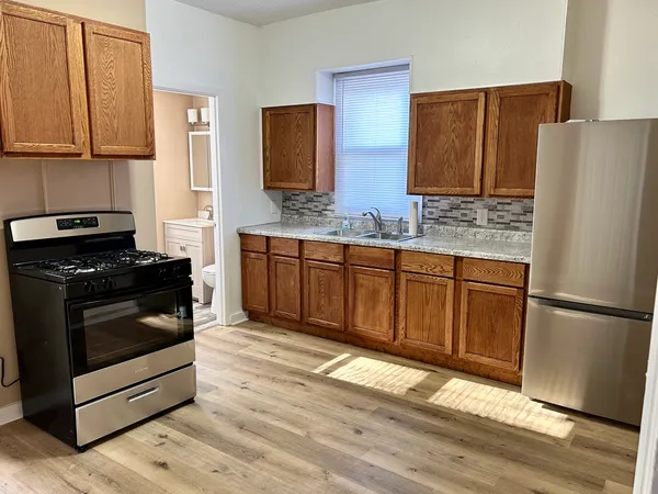 a kitchen with stainless steel appliances granite countertop a refrigerator stove and sink