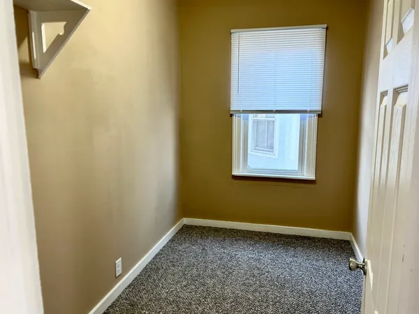 a view of a small space with wooden floor and a window