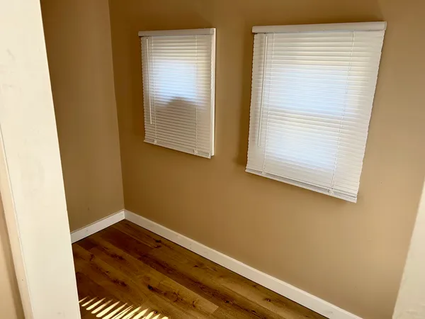 a view of a room with wooden floor and a window