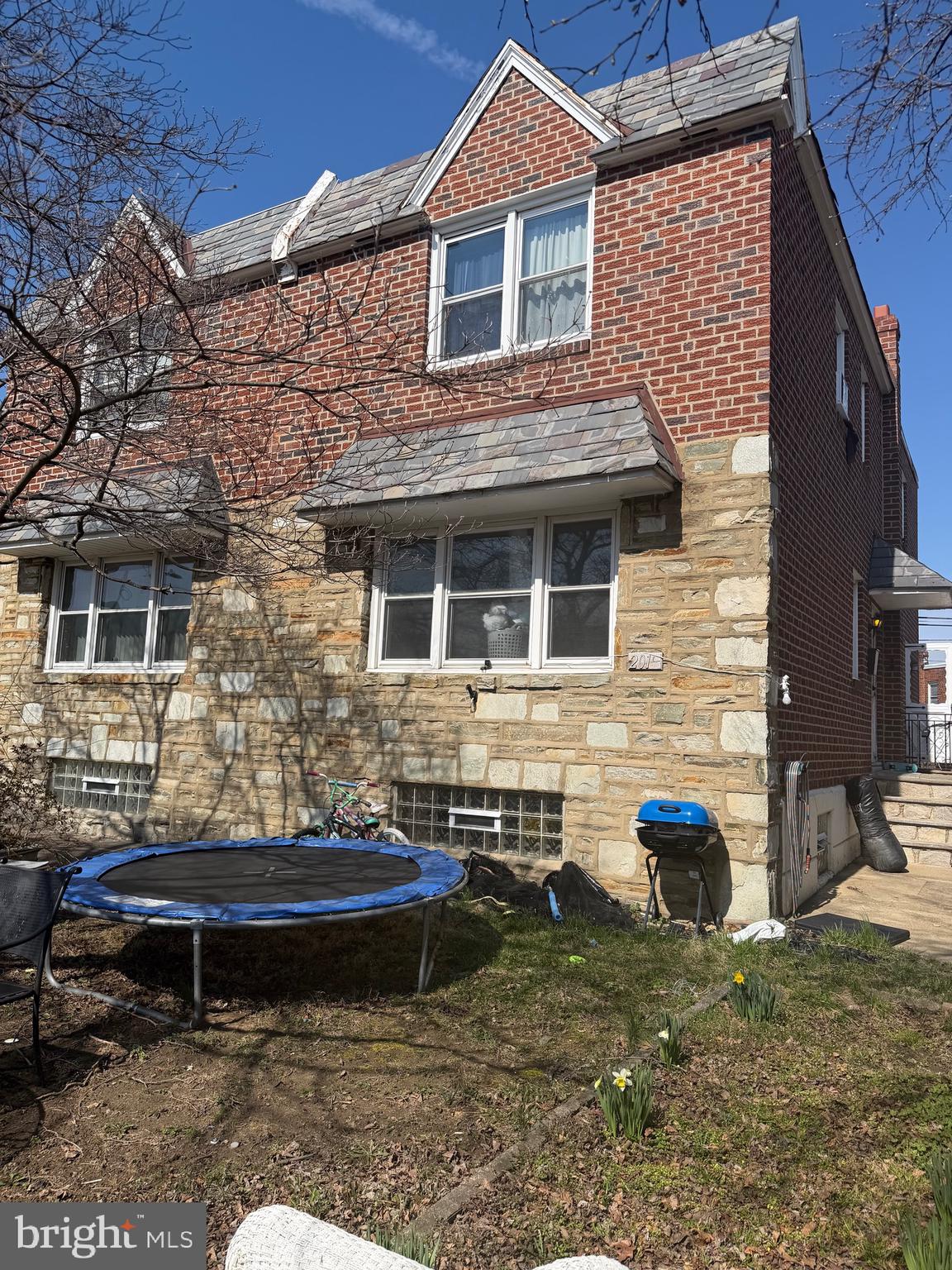 a backyard of a house with barbeque oven table and chairs