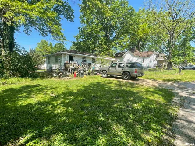 a view of a house with a yard and sitting area