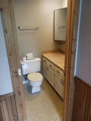 a bathroom with a granite countertop toilet and a sink
