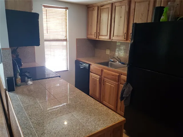 a kitchen with stainless steel appliances granite countertop a refrigerator a stove a sink and a cabinets