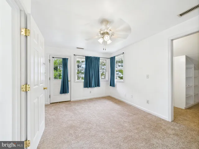 a view of an empty room with closet and racks