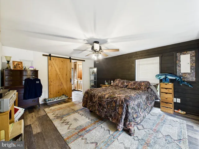 a bedroom with a bed and a flat tv screen on a dresser