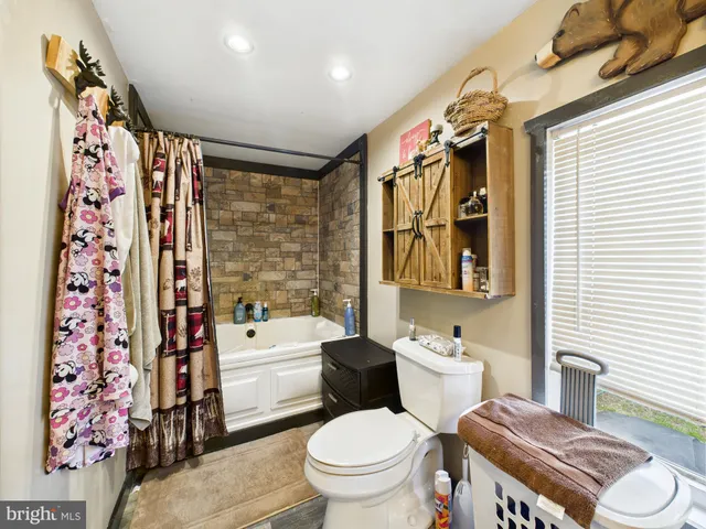 a bathroom with a granite countertop toilet sink and mirror