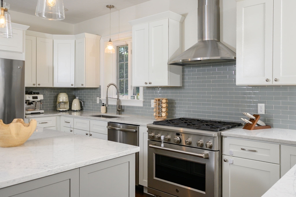 455 Broadway Hanover, MA 02339 - Photo 11 of 42 a kitchen with granite countertop a stove sink and cabinets