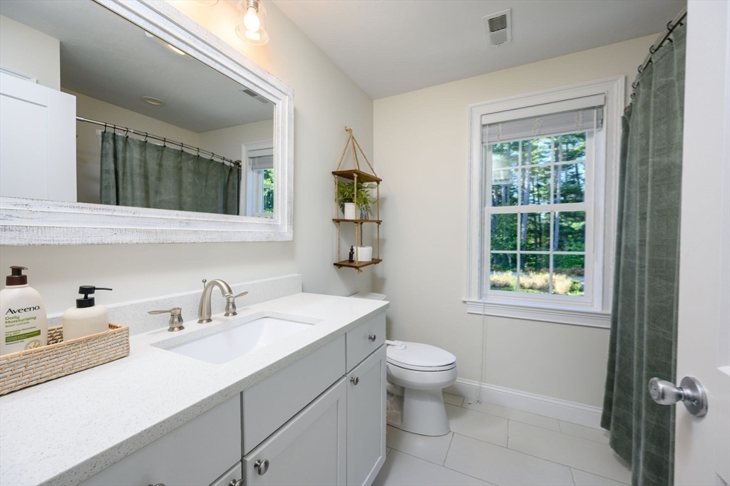 455 Broadway Hanover, MA 02339 - Photo 26 of 42 a bathroom with a sink toilet a mirror and window