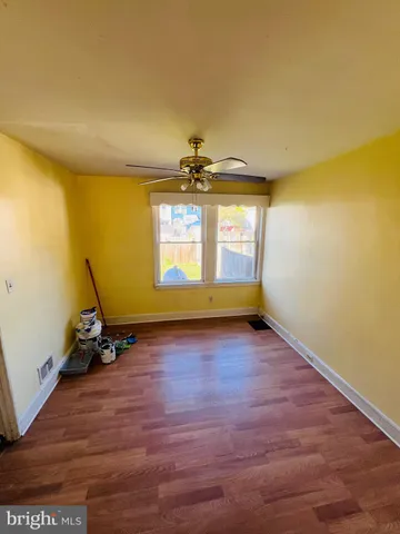a view of a room with gym equipment and wooden floor
