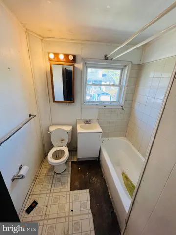 a bathroom with a toilet a sink a mirror and bathtub