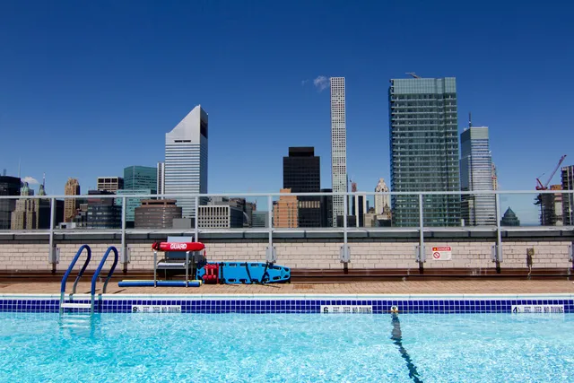 a view of a swimming pool with a bench and lawn chairs