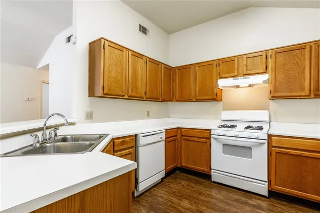 a kitchen with a sink cabinets and wooden floor