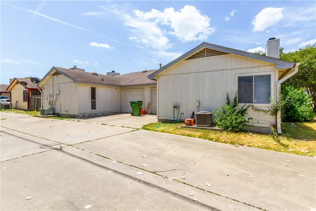 a view of a house with a yard and large tree