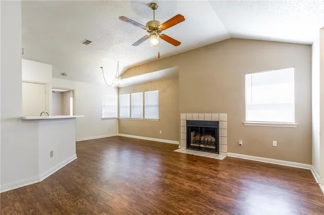 wooden floor fireplace and windows in an empty room