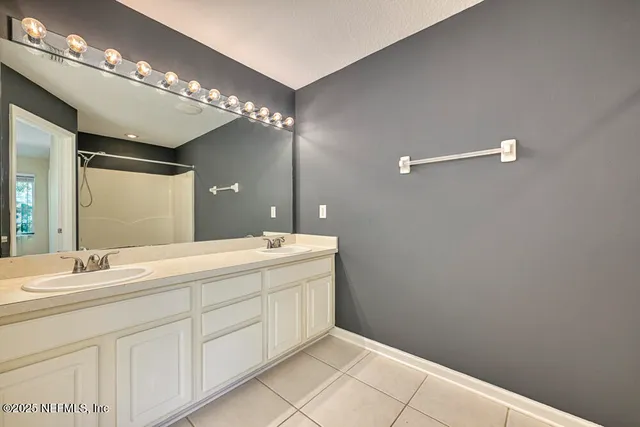 a bathroom with a double vanity sink and a mirror