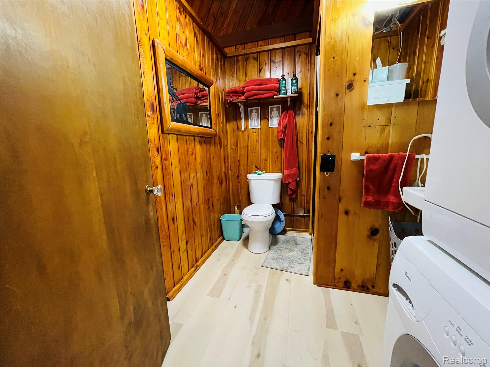 417 Ogemaw Road Rose City, MI 48654 - Photo 15 of 26 Wood-paneled walls and ceiling, light-toned wood-finish flooring, and built-in shelving