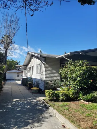 a front view of a house with a yard and potted plants