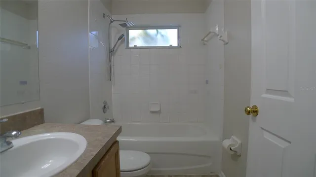 a bathroom with a granite countertop toilet a sink and bathtub