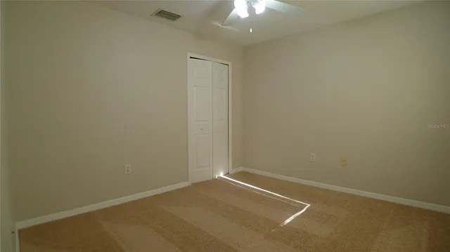 an empty room with a chandelier fan