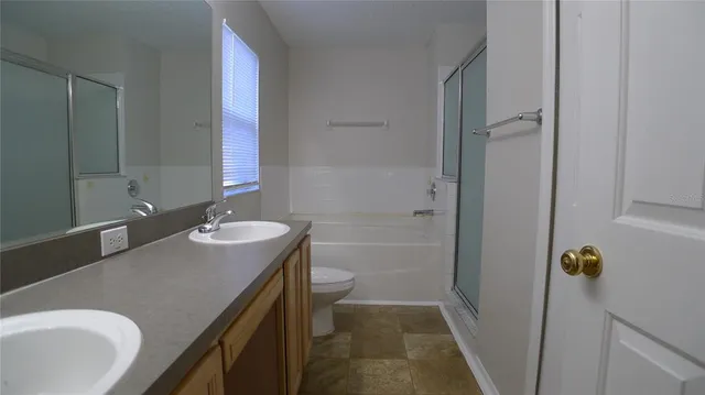 a bathroom with a sink and mirror with toilet