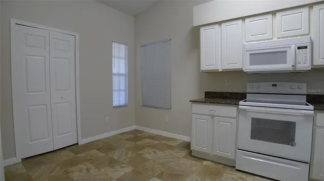 a kitchen with white cabinets and white appliances