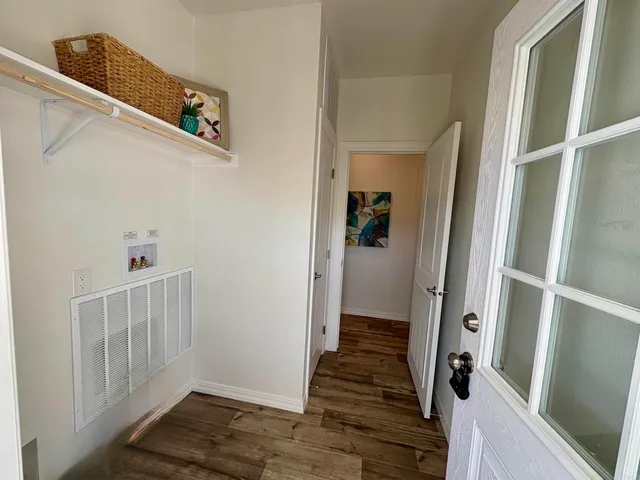 a view of a hallway with wooden floor and entryway