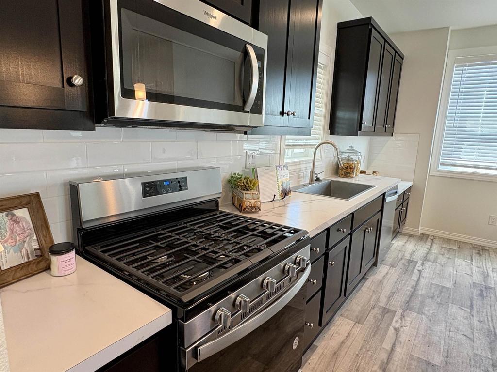 28890 Lilac Road, Unit 179 Valley Center, CA 92082 - Photo 3 of 21 a kitchen with stainless steel appliances a stove a sink and a microwave