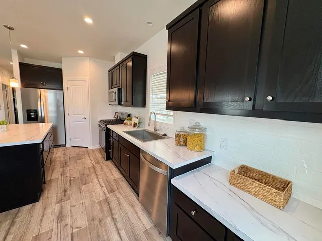 a kitchen with stainless steel appliances wooden cabinets and sink