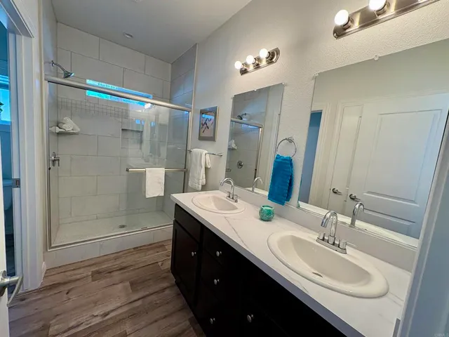 a bathroom with a double vanity sink mirror and shower