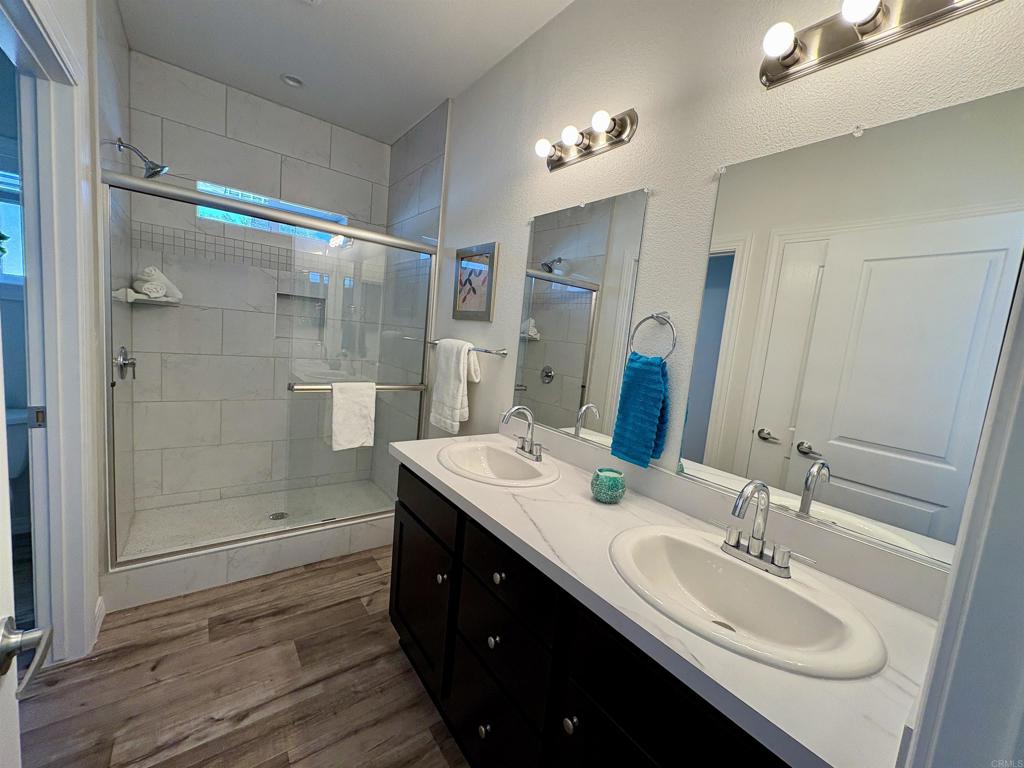 28890 Lilac Road, Unit 179 Valley Center, CA 92082 - Photo 10 of 21 a bathroom with a double vanity sink mirror and shower