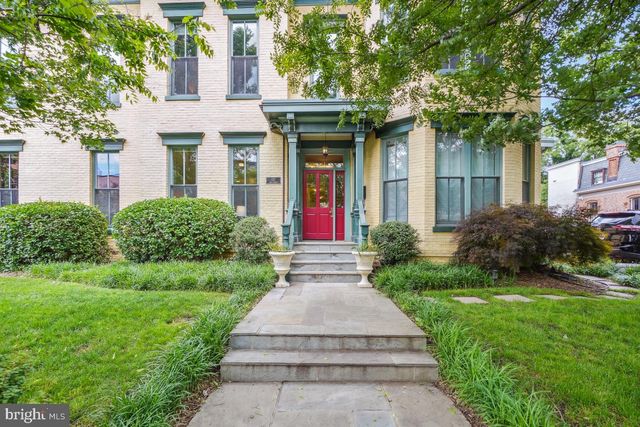 a front view of a house with a yard and plants