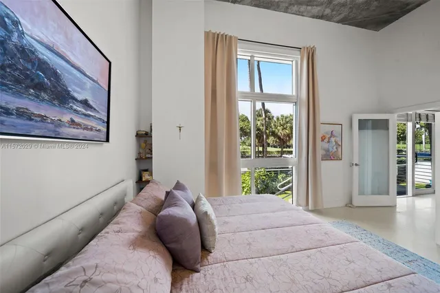 a bed sitting in a bedroom next to a window