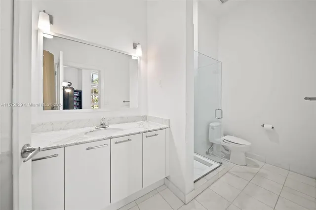 a spacious bathroom with a granite countertop sink toilet and mirror