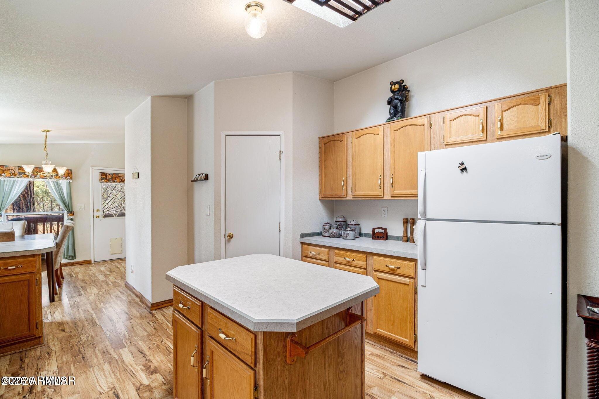 2908 Pine Rim Road, Unit LOT 7 Overgaard, AZ 85933 - Photo 12 of 24 a kitchen with a refrigerator a stove cabinets and wooden floor
