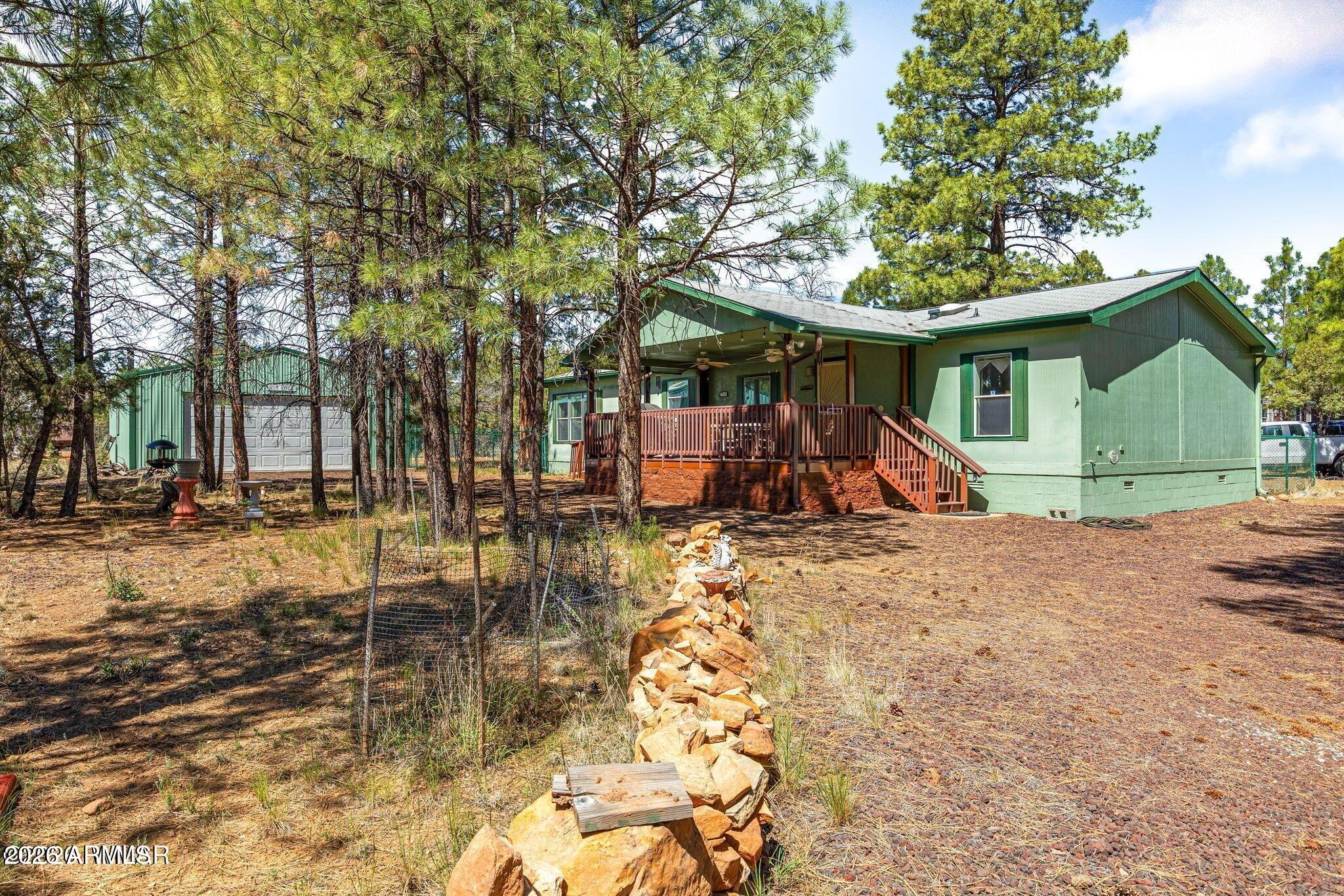 2908 Pine Rim Road, Unit LOT 7 Overgaard, AZ 85933 - Photo 2 of 24 a view of a wooden house with a yard and sitting area