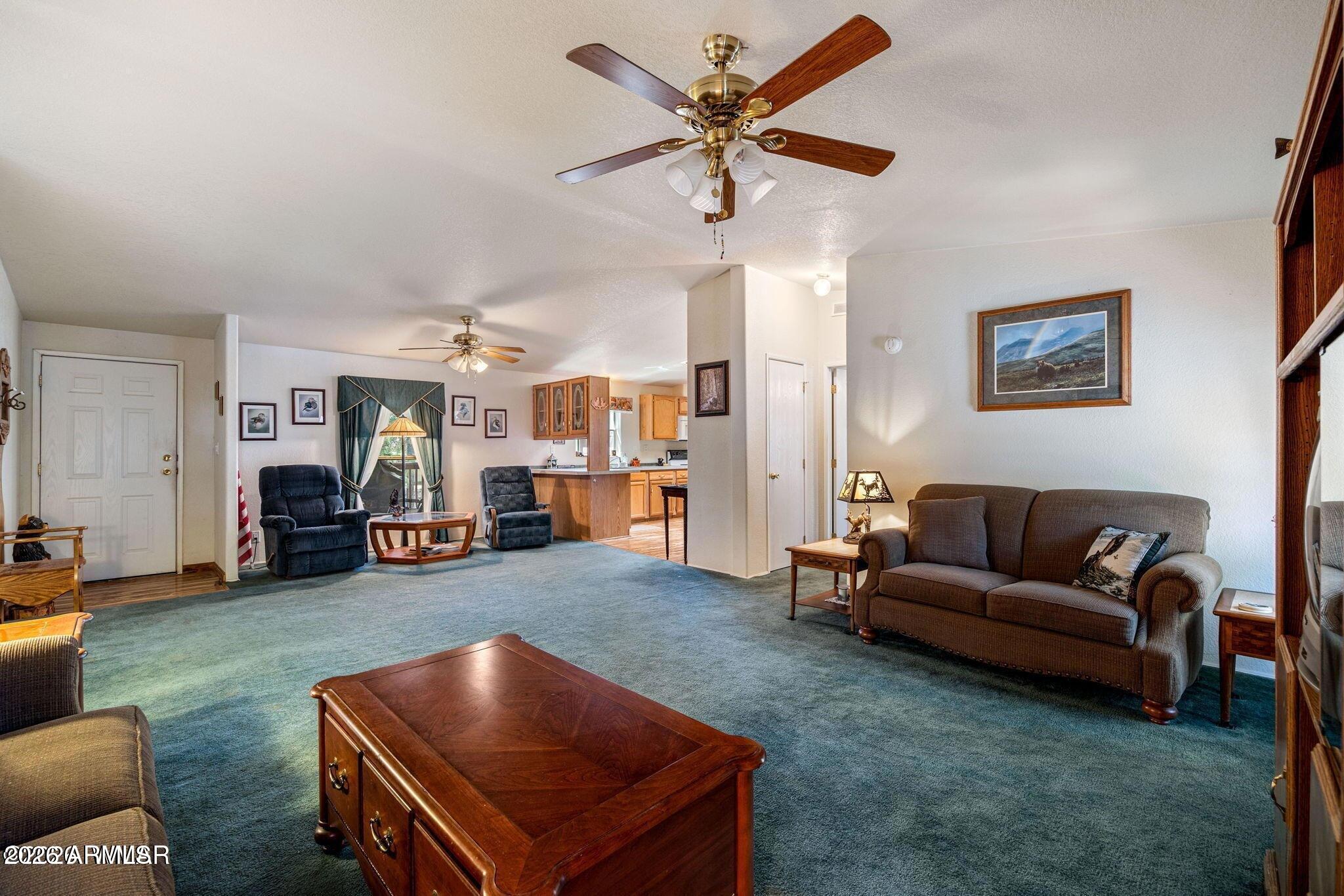 2908 Pine Rim Road, Unit LOT 7 Overgaard, AZ 85933 - Photo 9 of 24 a living room with furniture and a chandelier