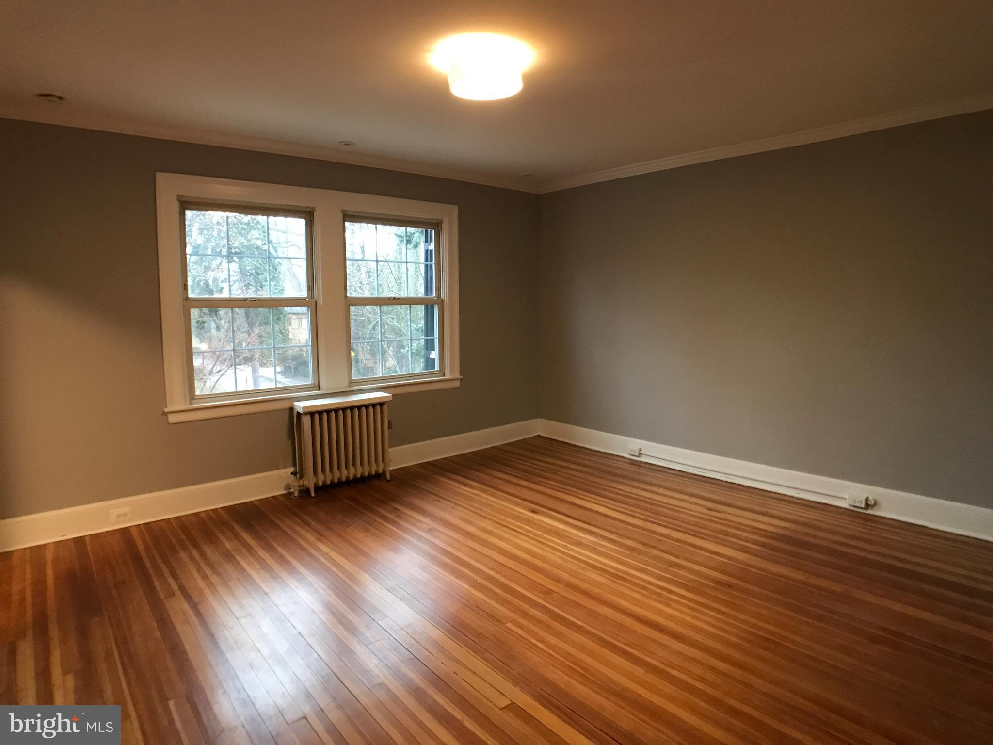 3959 Cloverhill Road Baltimore, MD 21218 - Photo 13 of 27 a view of an empty room with wooden floor and a window
