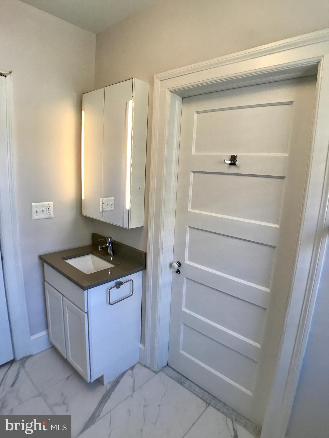 3959 Cloverhill Road Baltimore, MD 21218 - Photo 17 of 27 a bathroom with a granite countertop sink and a mirror