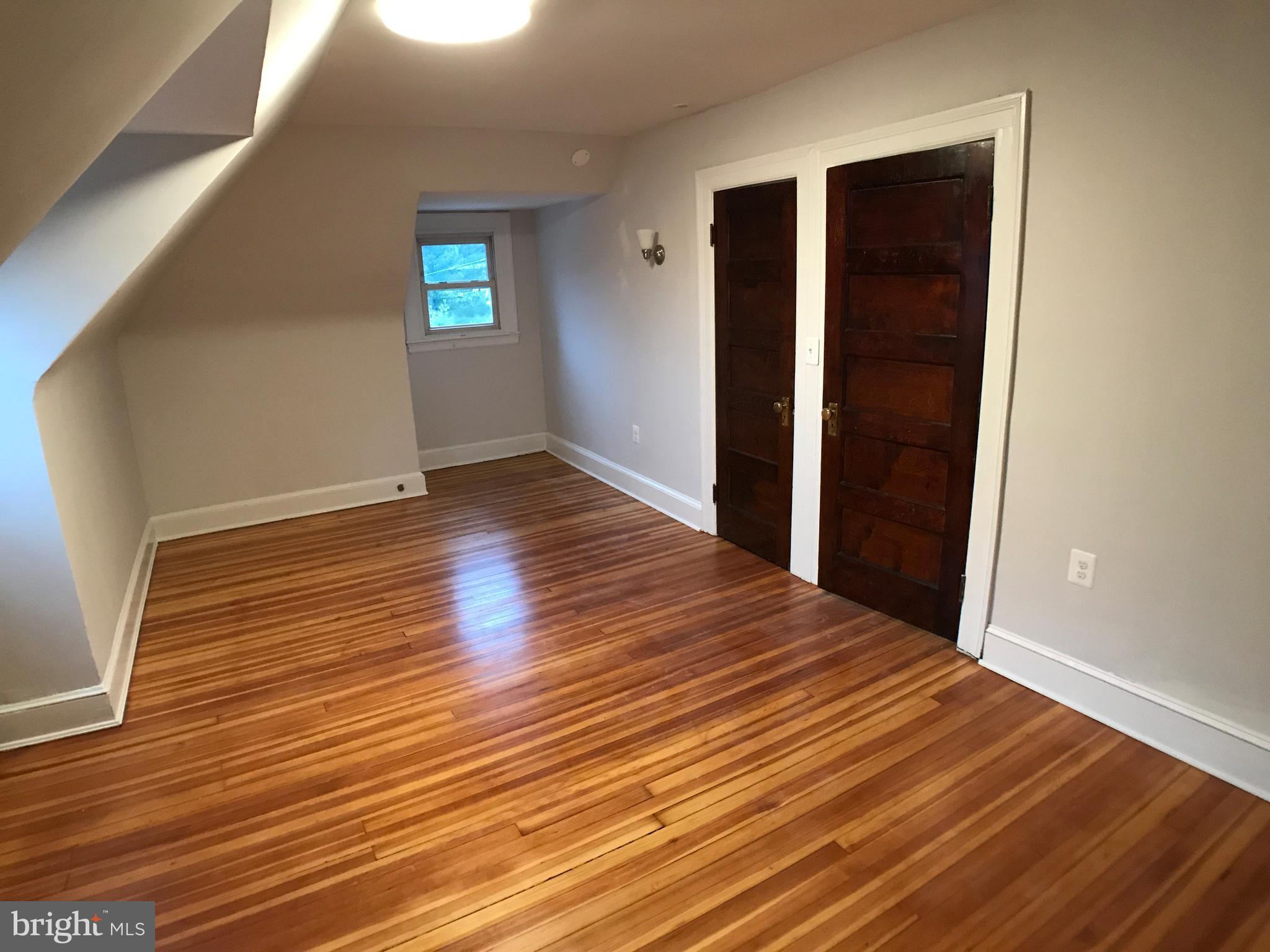 3959 Cloverhill Road Baltimore, MD 21218 - Photo 20 of 27 an empty room with wooden floor and windows