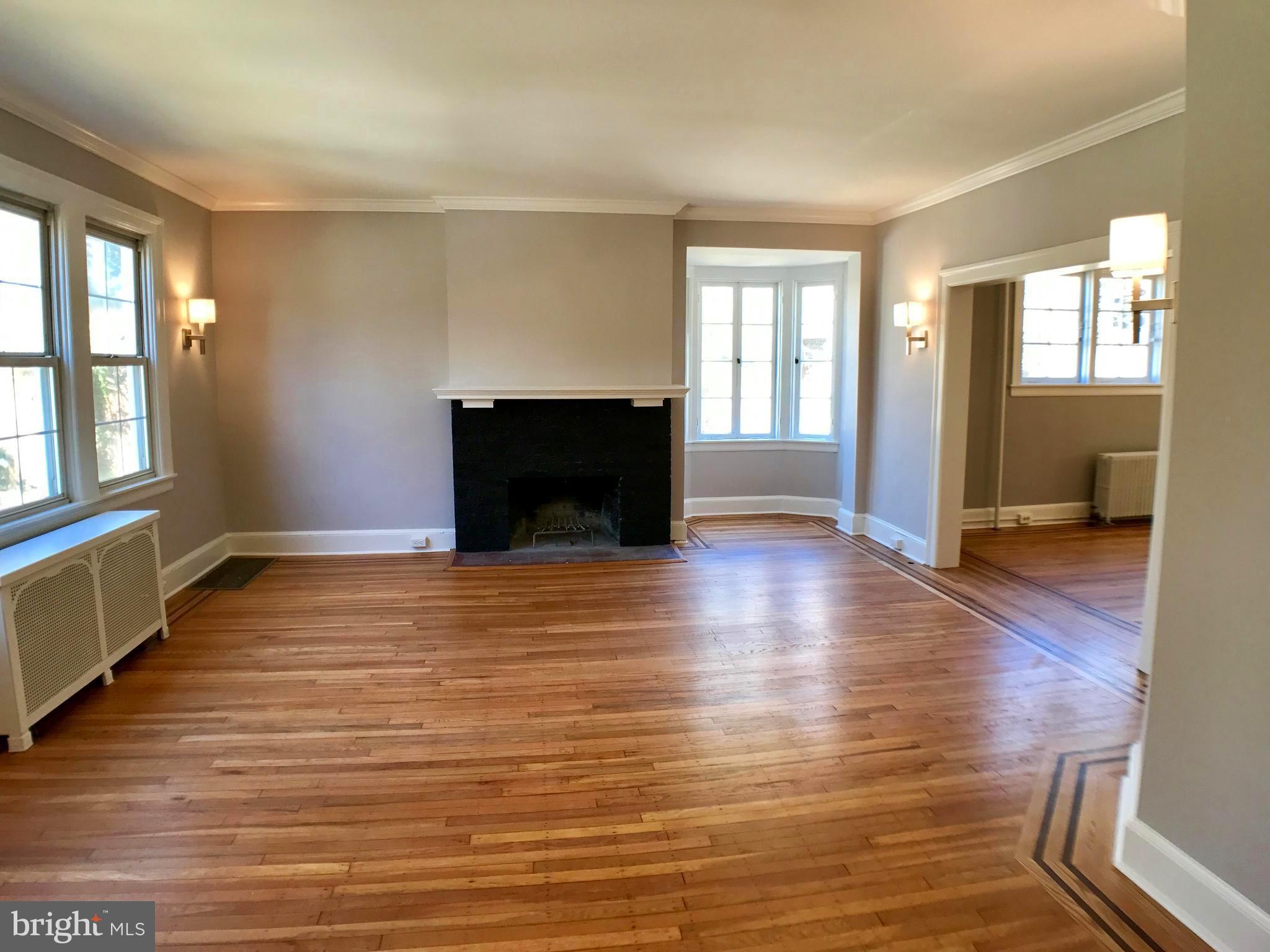 3959 Cloverhill Road Baltimore, MD 21218 - Photo 3 of 27 wooden floor fireplace and windows in an empty room