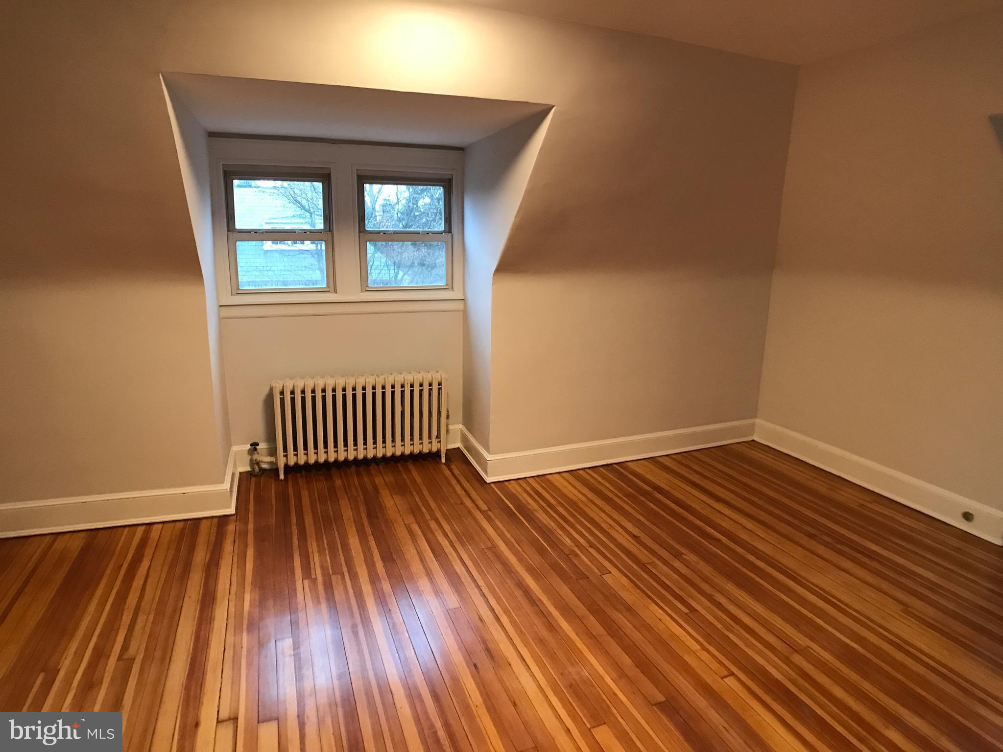 3959 Cloverhill Road Baltimore, MD 21218 - Photo 21 of 27 an empty room with wooden floor and windows